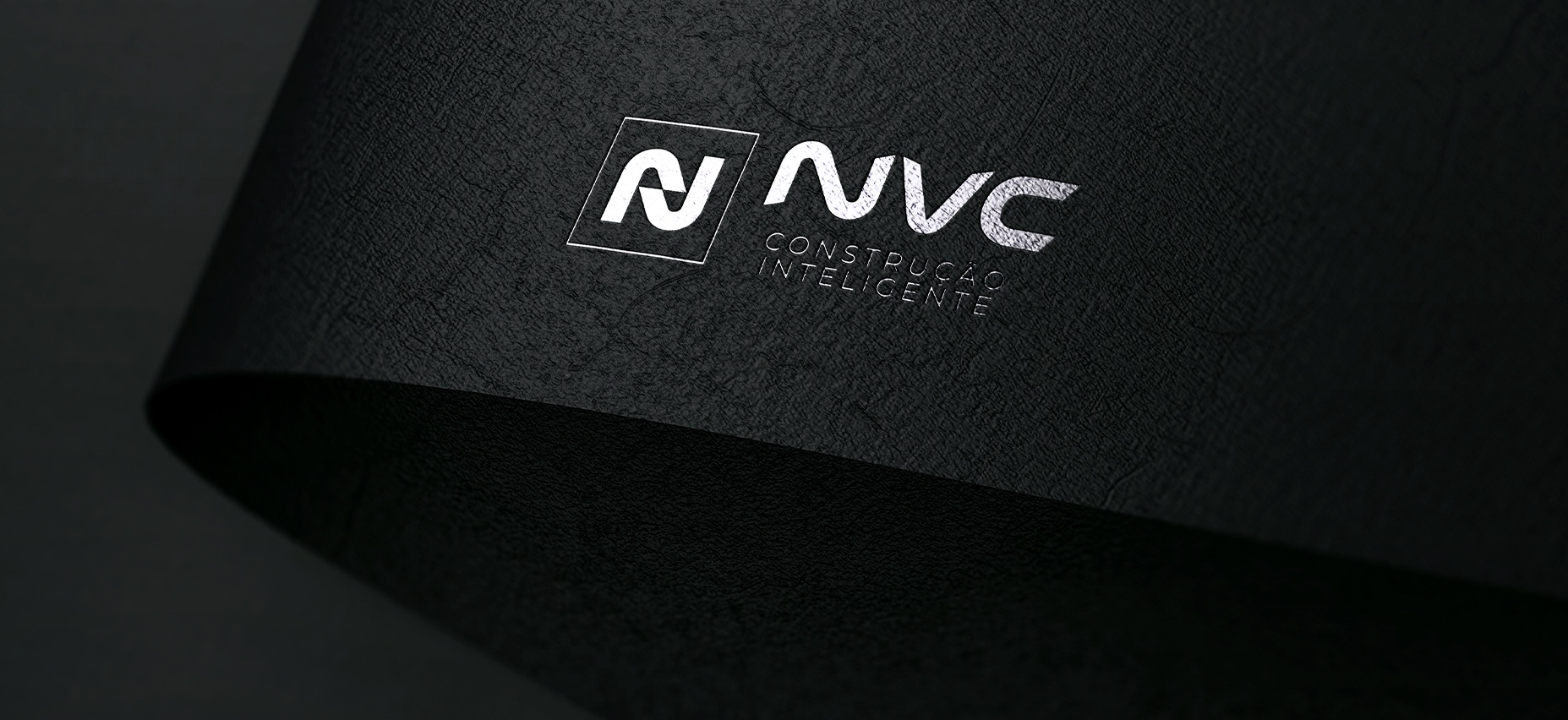 Prancheta 4 NVC logo mockup on dark textured paper